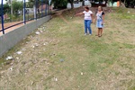Moradoras apontando para o lixo na área verde do bairro