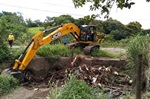 Equipe de obras realizando a limpeza de córrego
