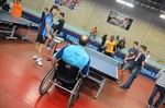 Wladimir Menezes, de costas, ensinando um aluno a jogar o tênis de mesa