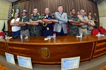 Com os braços entrelaçados, participantes de solenidade entoaram Canção da Despedida