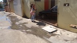 Mãe com criança de colo mora em frente ao vazamento de esgoto. Vereador já tomou providências