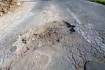 Foto mostra situação atual do asfalto na rua Maria Isabel da Silva