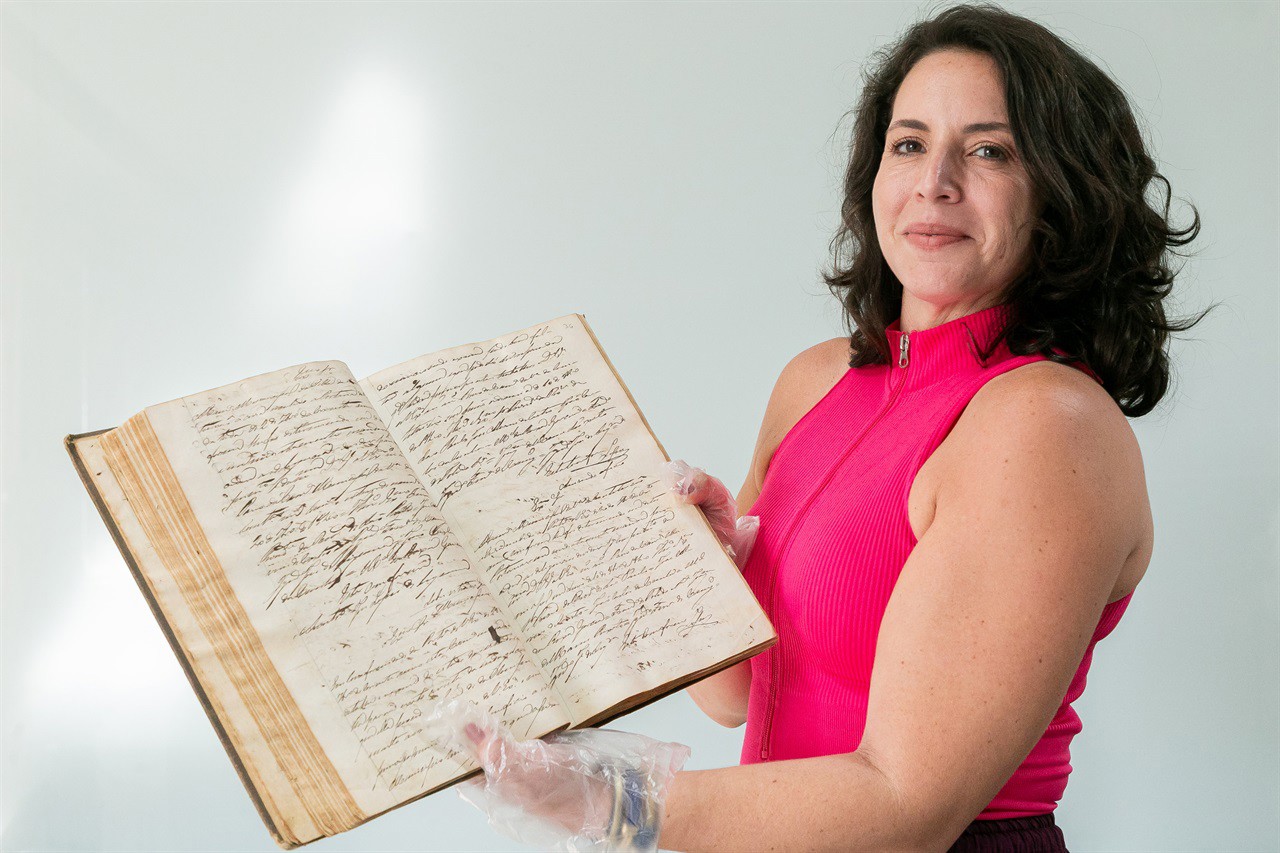 Giovanna Fenili Calabria, Chefe do Setor de Gestão de Documentação e Arquivo da Câmara exibe o "2º Livro de Ofícios da Câmara"