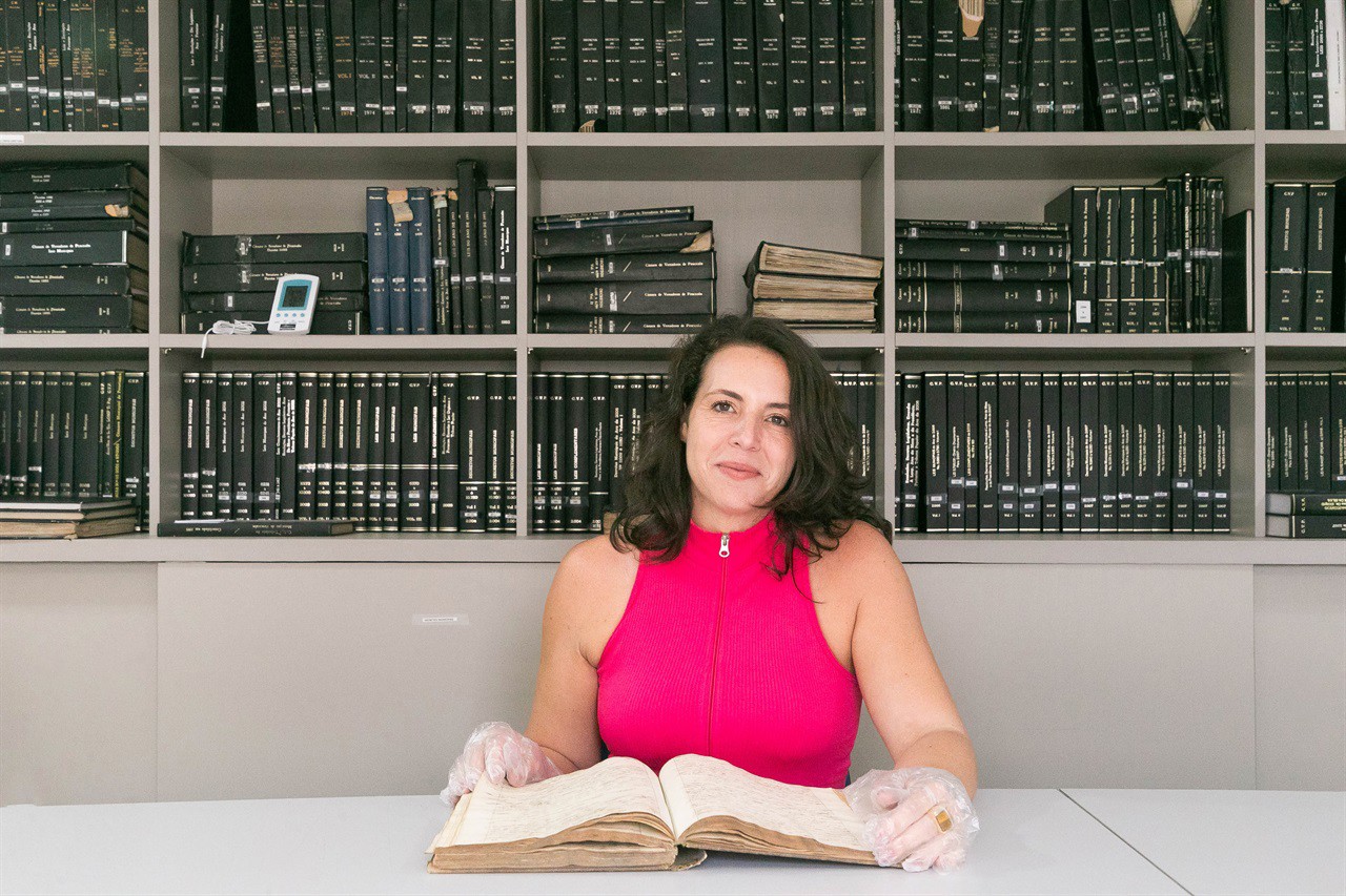 Giovanna Fenili Calabria, Chefe do Setor de Gestão de Documentação e Arquivo da Câmara manuseia o "2º Livro de Ofícios da Câmara"