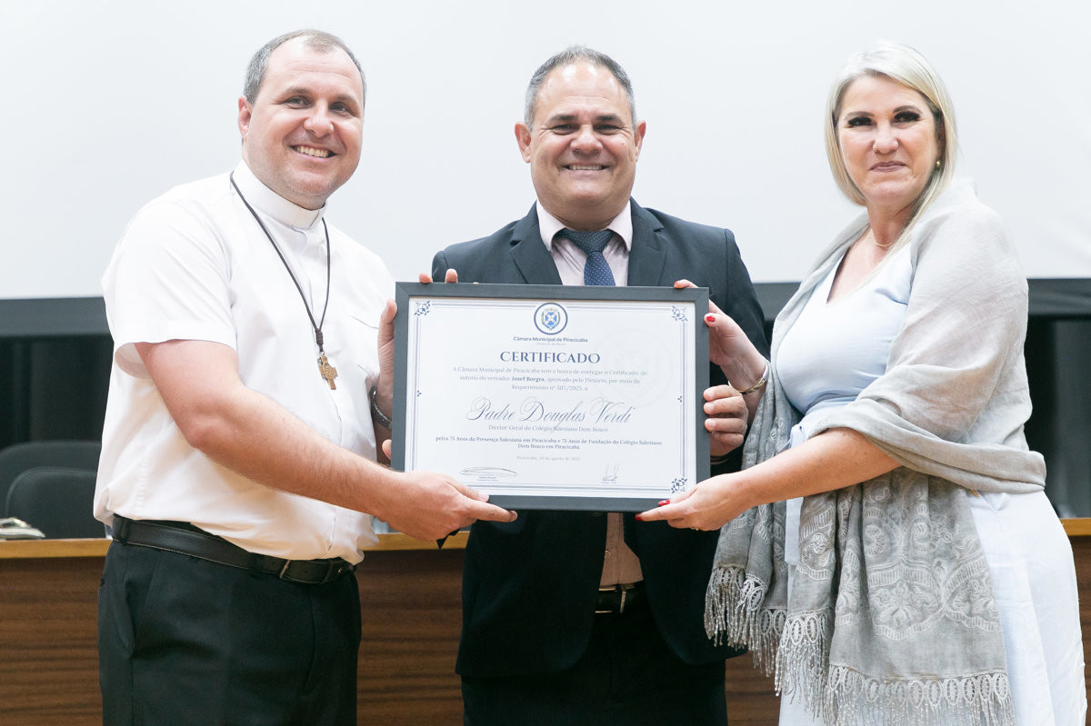 Padre Jonas Verdi, homenageado, vereador Josef Borges e Juliana Vicentin, secretária municipal de Educação