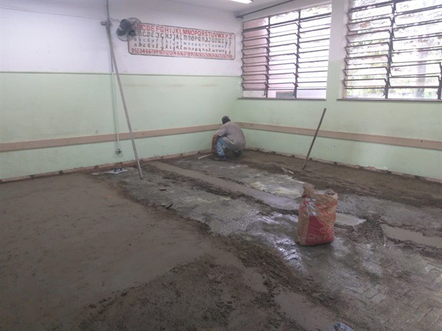 Foto mostra o trabalho de funcionários na troca dos pisos