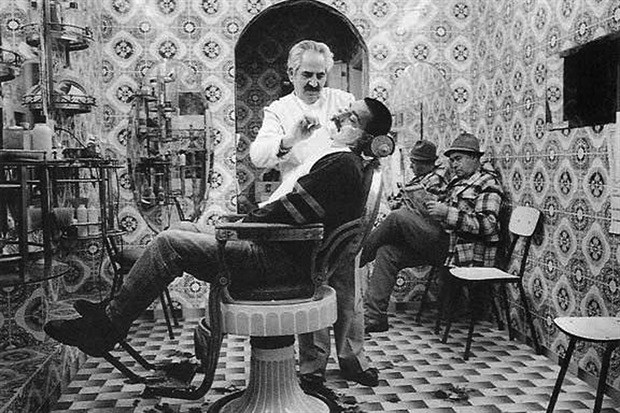 Imagem ilustrativa mostra barbeiro trabalhando em salão típico da primeira metade do século 20