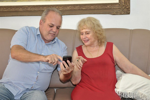 Gilmar Rotta mostra à professora aposentada Arlete fotos atuais do imóvel que abrigava a antiga escola "José Piacentini", no Pau D Alho